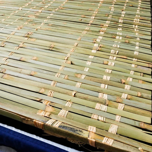 A close-up of a woven bamboo chess mat with light tan binding strips, shown above a text label reading 'Bamboo Schach Mats' on a white background.